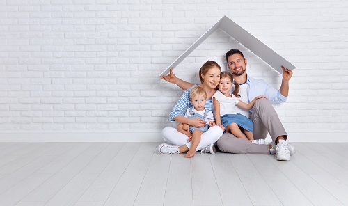 family sitting under cardboard roof